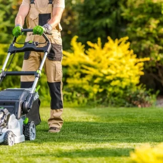 Picture of a person mowing a lawn with an electric lawn mower