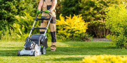 Picture of a person mowing a lawn with an electric lawn mower